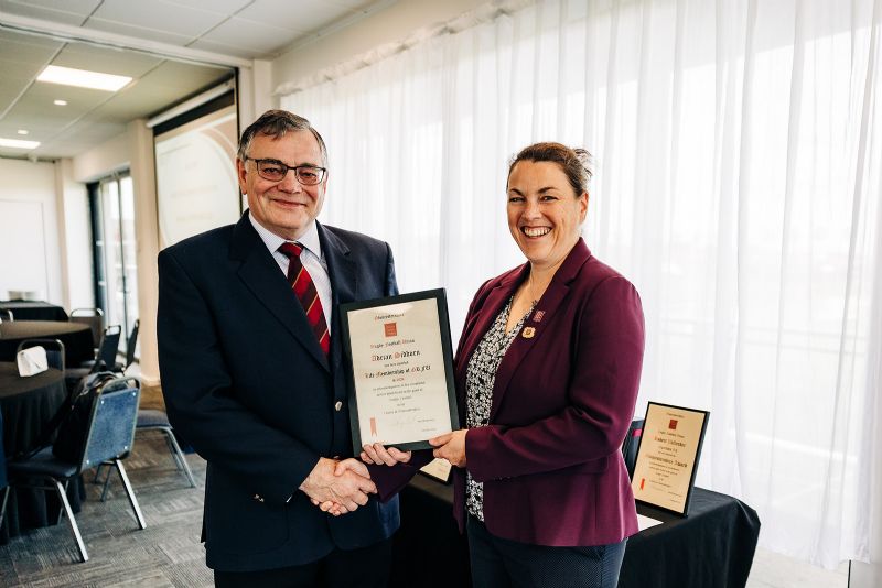 Emily Ryall handing past-president Adrian Siddorn his life membership of the Gloucestershire RFU