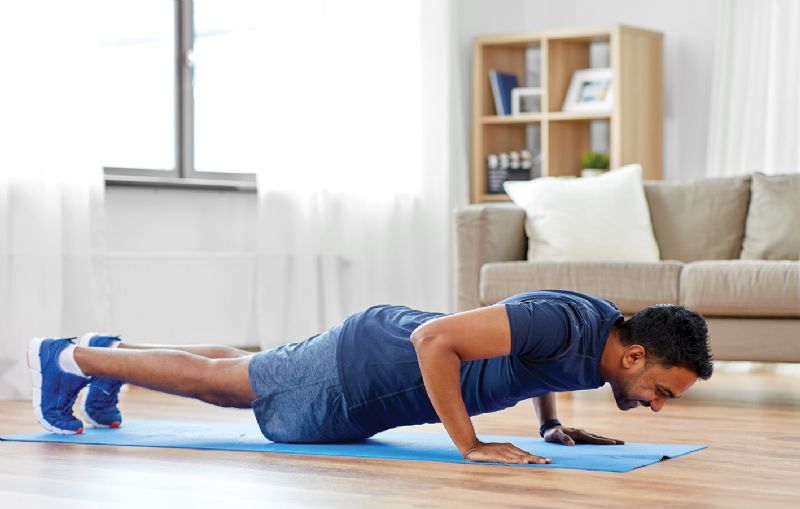 Man doing press ups in living room home workout fitness