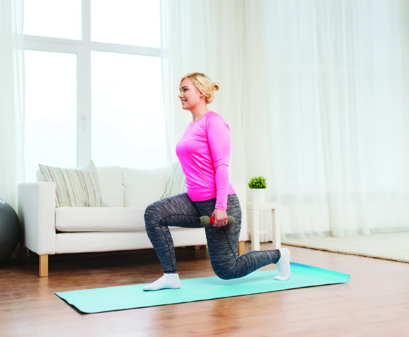 Young woman doing home workout fitness in living room lounge