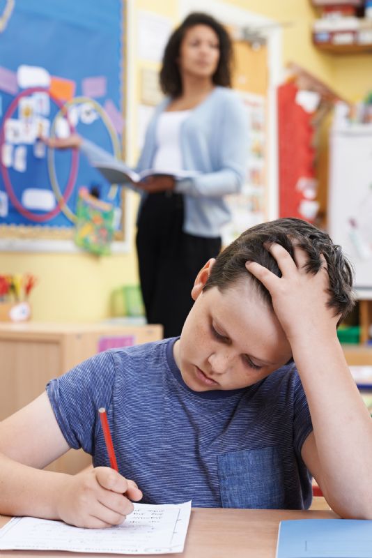 Young boy frustrated doing work at school dyslexia