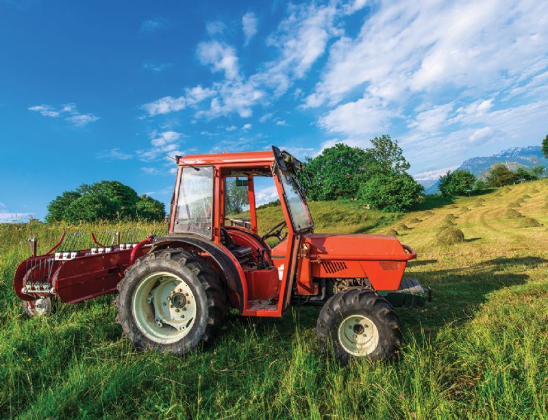 Red tractor in green field farm