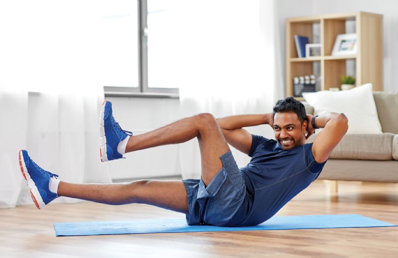 Man doing ab crunches in living room home workout